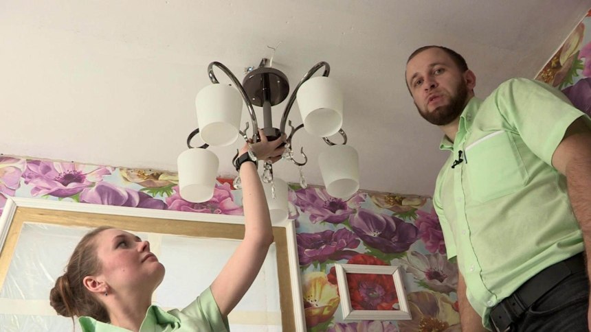 Парень вешает люстру